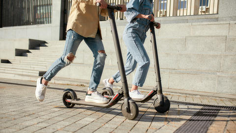 two people riding electric scooters