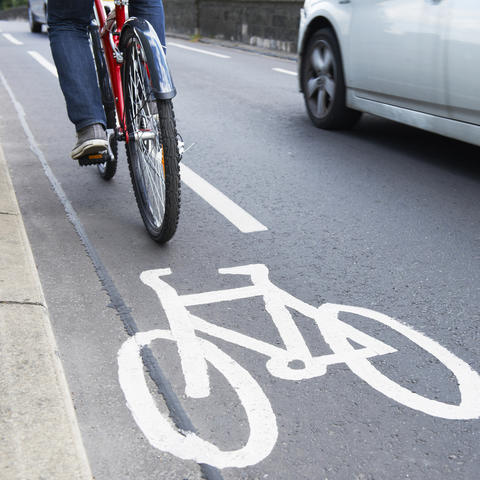 Bicyclist riding alongside a car