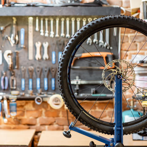 bike wheel propped up on tool bench