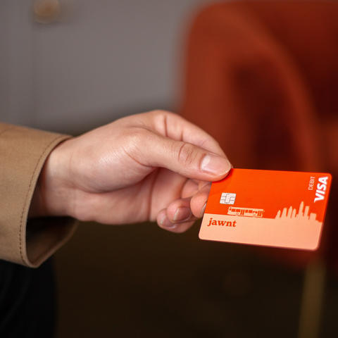Person holding an orange debit card