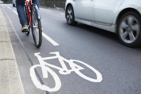 Bicyclist riding alongside a car